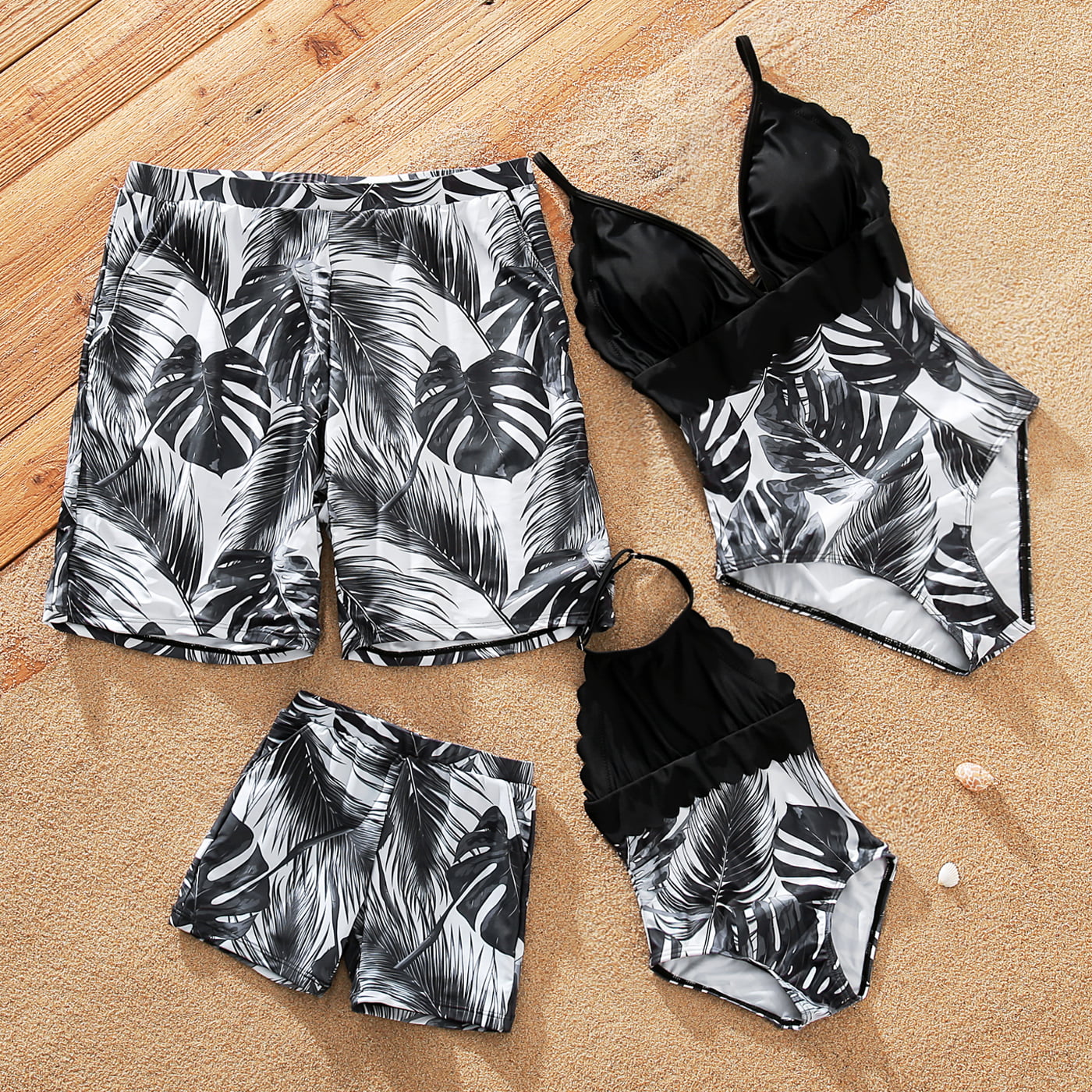 a matching set of family swimsuits with a black and white tropical floral print