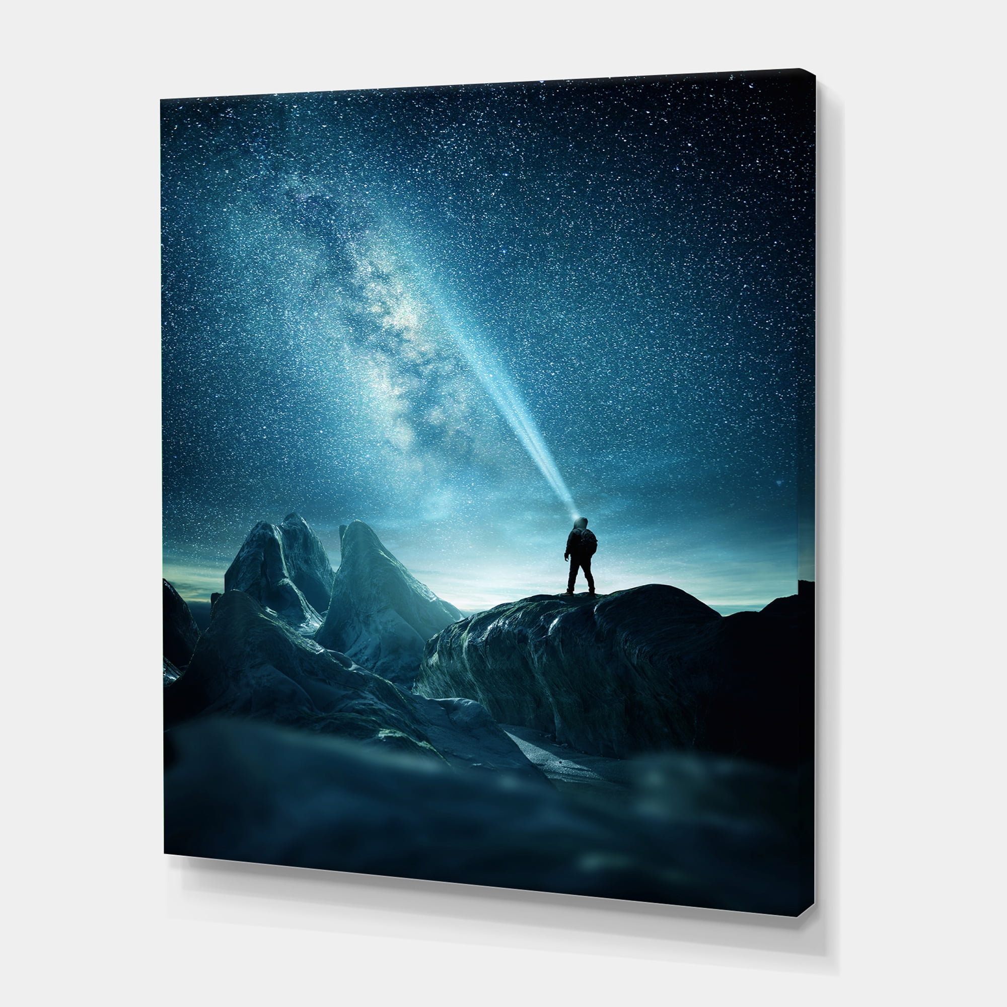 A Light Shining by A Man Shining Into The Night Sky 12 in x 8 in Photography Canvas Art Print, by Designart