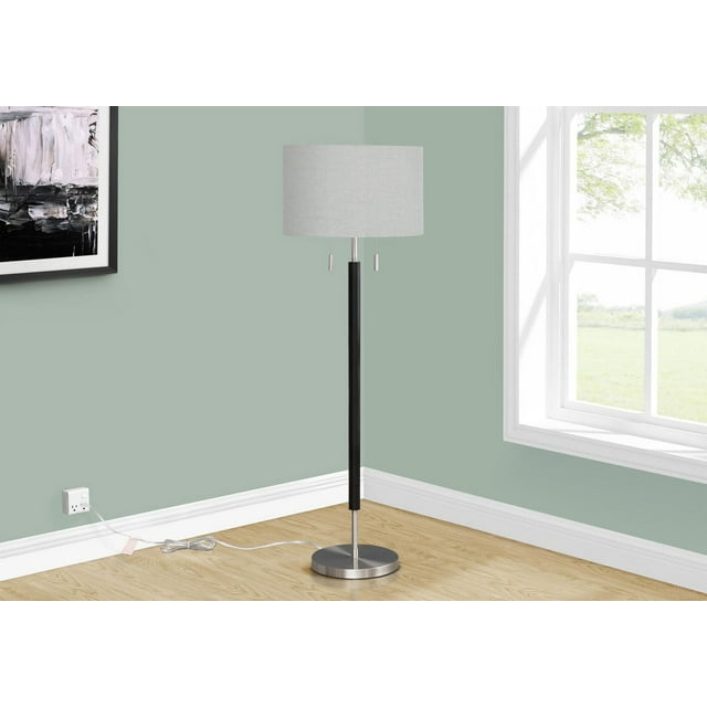 Contemporary 60-inch tall floor lamp featuring a grey fabric shade, nickel metal base, and black central pole placed in the corner of a room with light green walls and wood flooring.