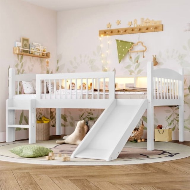 cama de techo twin xl con estanterías de almacenamiento, cama de techo inferior de madera maciza con luces led y barandillas de larga duración, sin necesidad de resorte de caja, blanco — Vista frontal 3/4 de litera Twin XL blanca de madera maciza con barandillas verticales, escalera lateral y rampa frontal; estantes integrados con libros y objetos decorativos, luces LED empotradas bajo la cama superior y lamas visibles sin colchón. Ambientación infantil con pared decorada, alfombra y juguetes; a menudo usada como espacio de estudio compacto en dormitorios pequeños.