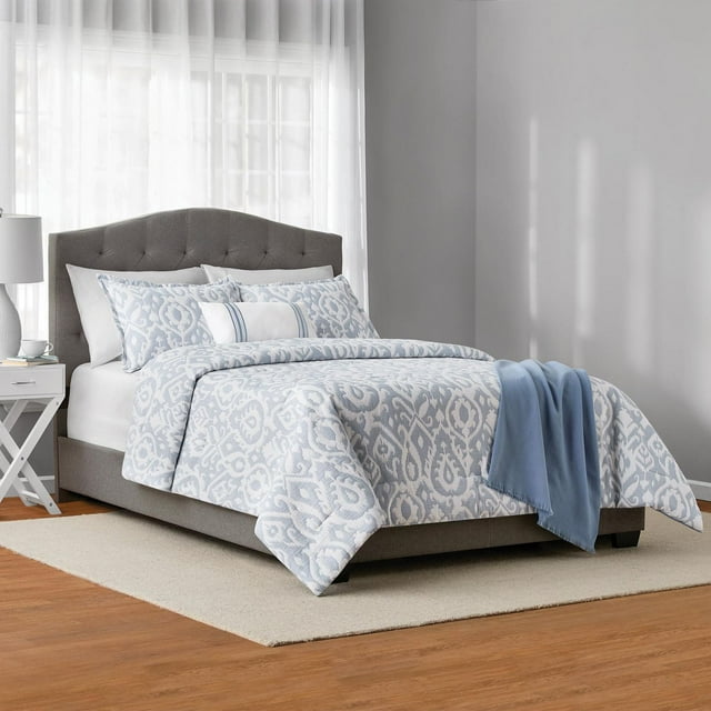 Double/Queen bed dressed with Mainstays 5-piece Ikat comforter set in light blue and white geometric pattern, including coordinating pillows and a folded blue throw on the side.