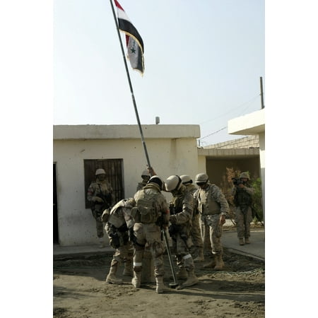 October 10 2004 - Soldiers from the Iraqi Special Forces Shawanis Brigade raise the Iraqi National Flag in front of the office of the mayor of Fallujah Poster