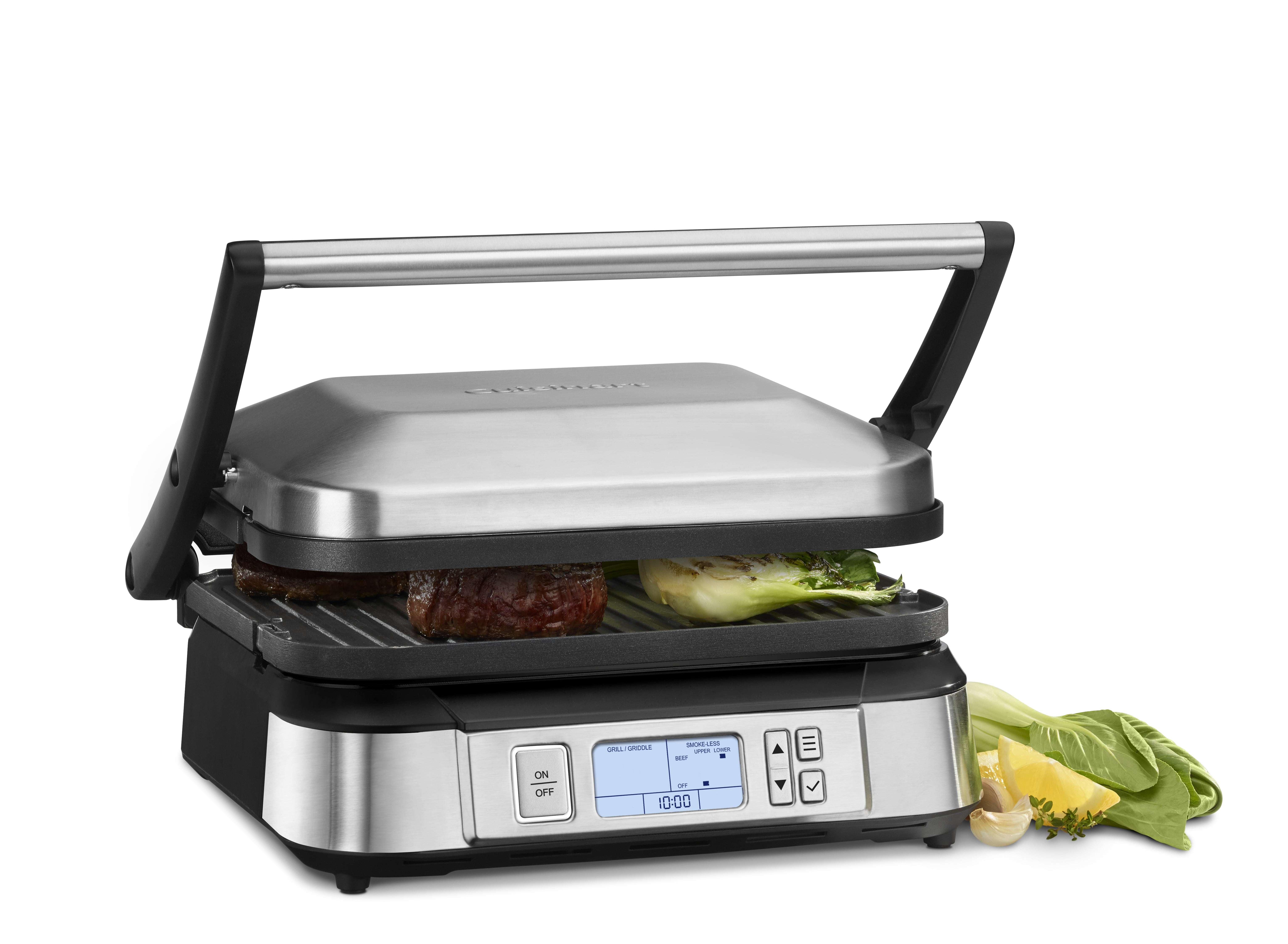 A silver and black Cuisinart Grills Contact Griddler with Smokeless Mode with two Filet Mignon patties and green vegetables
