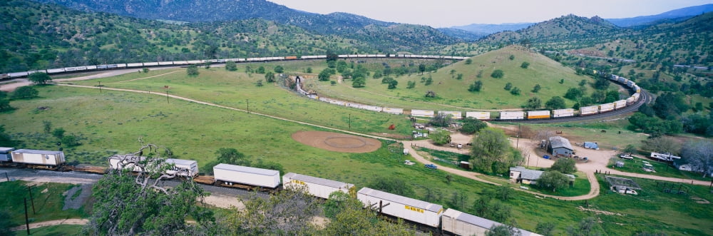 The Tehachapi Train Loop near Tehachapi California is the historic location of the Southern Pacific Railroad where freight trains gain 77 feet in elevation and show freight cars traveling in giant loo