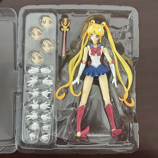 anime amoled panorámico sailor moon pvc figura de acción modelo juguetes — figura PVC de Sailor Moon de 14 cm en pose erguida con traje marinero azul y blanco y lazo rojo; cabello rubio largo en coletas y botas rosa; bandeja transparente incluye tres cabezas intercambiables, varita y varios pares de manos intercambiables; sin caja visible, versión remasterizada, marca Arco Iris Latino, regalo para amigos, a menudo usada como pieza de exhibición de colección.