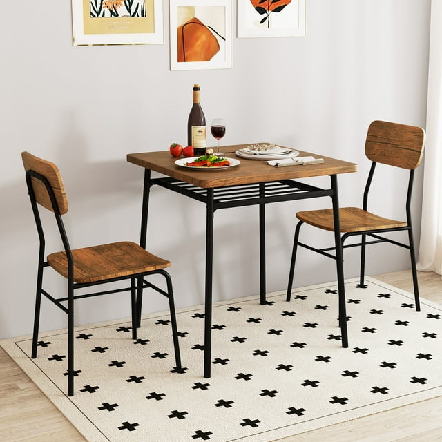 Gymax 3-Piece Wood Square Kitchen Table & Chair Set with Metal Frame Storage Rack. The set includes a square table with a veneered MDF wood tabletop and two matching chairs, all supported by a sturdy black metal frame. The table features a built-in lower storage rack for organizing dining essentials. The chairs have curved backrests and wide seats for comfort. The set is displayed in a cozy dining room with a patterned rug and wall art, showcasing its compact and space-saving design.