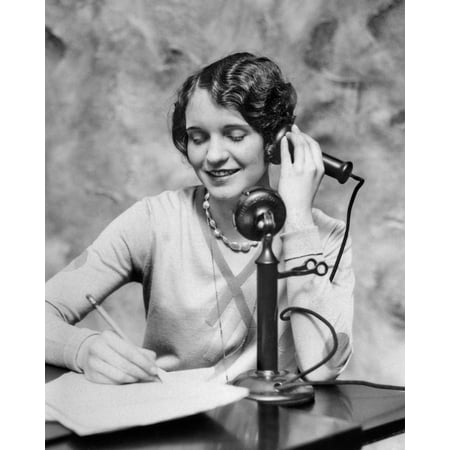 - 1920s Smiling Woman Sitting At Desk Writing And Talking On Candlestick Telephone Print By Vintage Collection