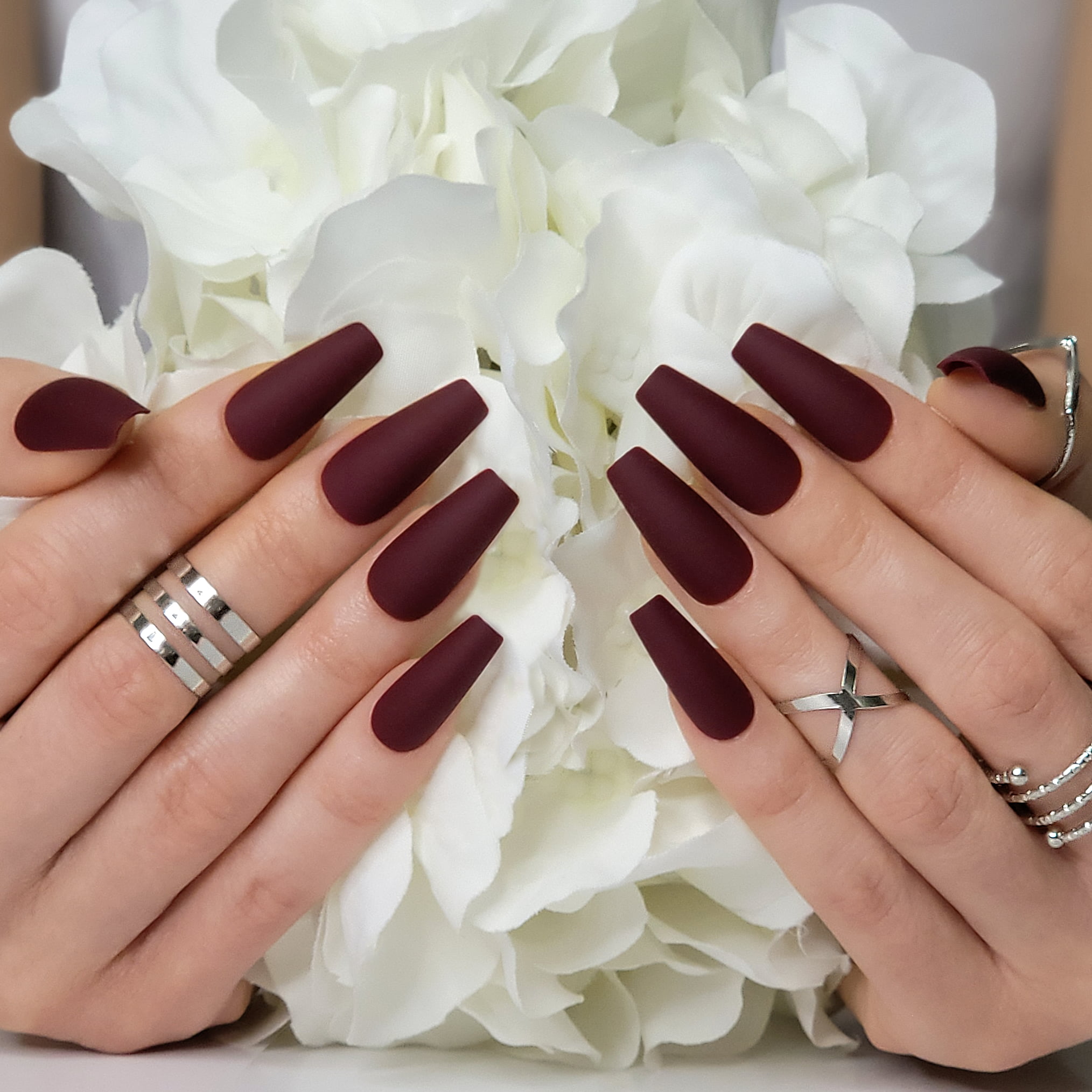 Download A Woman's Hand With Burgundy And Silver Nails | Wallpapers.com