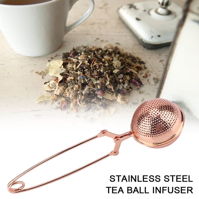 bola de te, colador de té, filtro de té de acero inoxidable, infusor de bolas de té para preparar té de hojas sueltas y especias para triturar, con mango largo, oro rosa amonsee Infusor de bola AMONSEE en acabado oro rosa, vista 3/4; esfera perforada de acero inoxidable 304 con cierre de bisagra y mango largo de varilla, aprox. 18 x 5 cm, mostrado sobre fondo blanco con hojas de té sueltas y una taza; también apto para infusionar pequeñas especias en caldos.