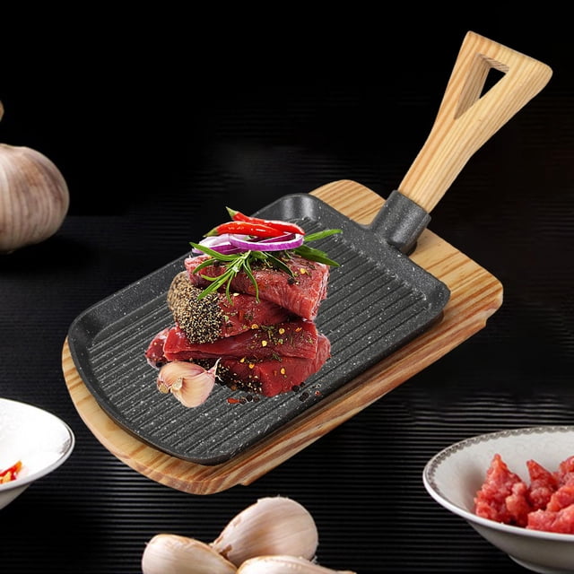 Cast Iron Nonstick with Detachable Handle Griddle BBQ Grilling Pan Griddle Steak Frying Pan for Kitchen Steak Breakfast Fish Vegetables Home S. A rectangular cast iron griddle with a detachable wooden handle, featuring a nonstick surface and parallel ridges for grilling. The pan is displayed with seasoned steak and vegetables, placed on a wooden insulation board. Suitable for cooking steak, fish, vegetables, and more on various stovetops, including gas, induction, and electric.