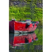 Small, wooden fishing boat moored to the shore with a mirror image reflection in the calm water in the coastal town of Getaria; Getaria, Gipuzkoa, Spain Poster Print by Carson Ganci (12 x 19)