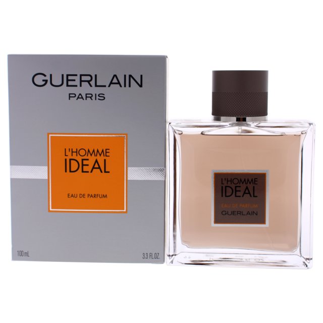 Guerlain L'Homme Ideal Eau De Parfum Spray for Men, 3.3 Ounce. A rectangular glass bottle with a black cap, containing a warm amber-colored fragrance. The packaging features a grey box with orange and black accents, showcasing the product name and brand. Designed by Guerlain and introduced in 2014, this eau de parfum includes notes of citruses, rosemary, almond, tonka bean, and leather.