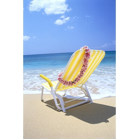 back view of yellow beach chair in sand gentle shore waters pink lei