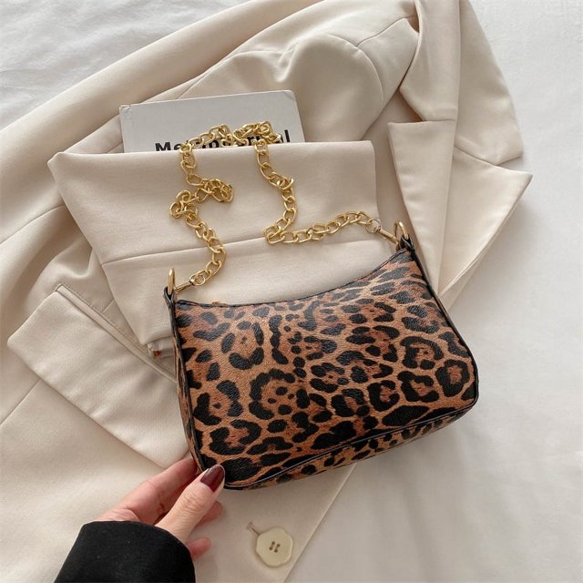 Bolso de mano estilo nicho francés de media luna para viajeros, elegante y sencillo, con estampado de leopardo y un solo hombro bajo el brazo, para invierno de 2025.
