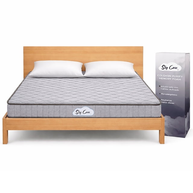 colchón matrimonial sky care purify 15 cm de memory foam con carbón activado, frontal centrado sobre base de madera, color gris 135×190 cm y 15 cm de grosor, tapizado acolchado en rombos, etiqueta Sky Care visible y caja compacta a la derecha; densidad media (suave) para soporte envolvente y memory foam con carbón activado para frescura y control de olores, también suele usarse en habitaciones de invitados o departamentos por su empaque compacto.