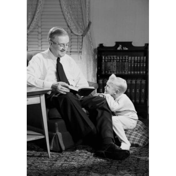 Grandfather reading to grandson in living room Poster Print (18 x 24 ...