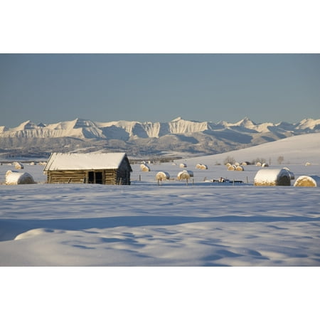 Snow Covered Log Cabin And Hay Bales In A Field With Snow Covered Mountains Okotoks Alberta Canada Canvas Art - Michael Interisano  Design Pics (19 x