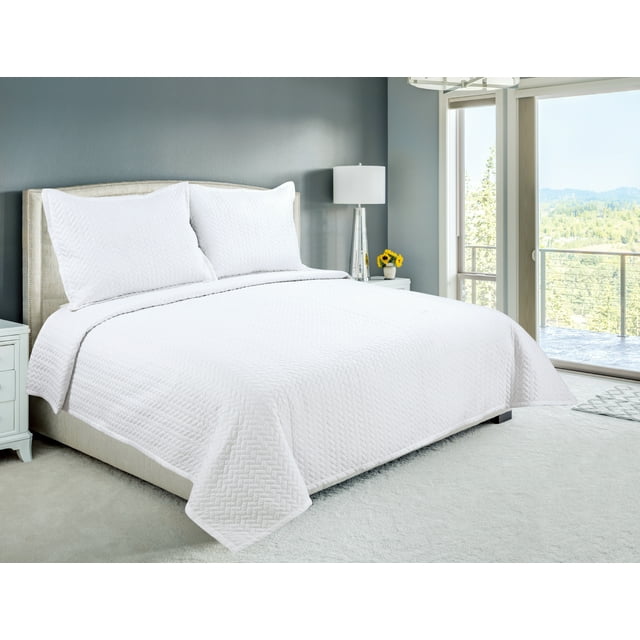 ultra soft white herringbone patterned quilt set with embroidered stitching covering a king-size bed with matching pillow shams in modern bedroom