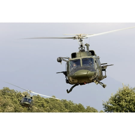 Two Italian Air Force AB-212 ICO helicopters practice low level flying in the valleys near Naples Italy Both helicopters are armed with MG 4259 762mm machine guns Poster Print