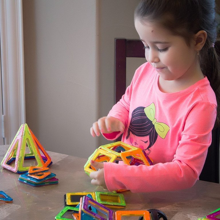 Young Child Building Geometric Magnetic Shapes Into A Creative Building At  Home Indoors For Education Problem Solving Fun Enjoyment And Leisure Stock  Photo - Download Image Now - iStock