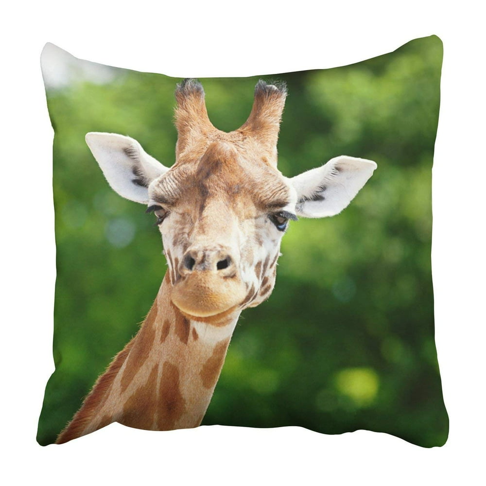BPBOP Close up of a giraffe in front of some green trees Pillowcase