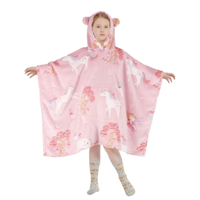 Pink oversized wearable hoodie blanket for kids decorated with white unicorns, pink trees, and moons, made of soft plush flannel fleece with a hood featuring ears and a giant front pocket.