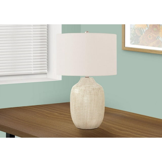Contemporary table lamp with 26-inch height, cream ceramic textured base, and ivory drum shade on wood surface.