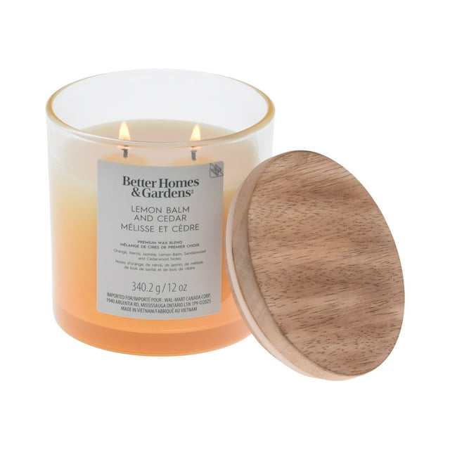 Scented 2-wick Better Homes & Gardens ombre jar candle in lemon balm and cedar fragrance, burning with wooden lid off to the side.
