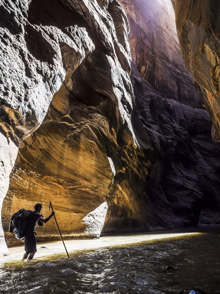 A hiker makes his way over the rocky river bottom of the Virgin River
