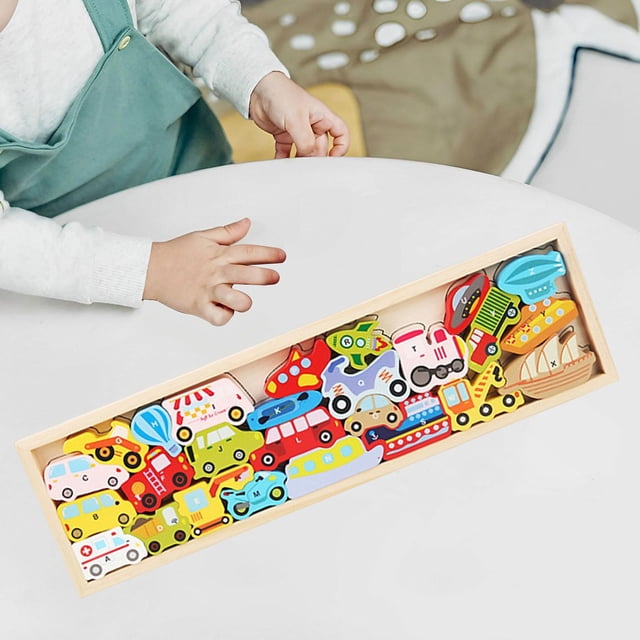 bloque de apilamiento de equilibrio de madera, habilidades motoras finas, juego de equilibrio, equilibrio de coordinación mano-ojo de construcción y transporte bandeja rectangular con bloques de madera en forma de vehículos (auto, camión, autobús, tren, barco y avión) en colores rojo, azul, amarillo y verde, vista cenital; piezas recortadas con bordes lisos sobre base de madera natural, manos de niño junto a la bandeja; tamaño 45 cm x 13 cm x 1.8 cm. Ideal para practicar coordinación mano-ojo y actividades de clasificación por color en familia.