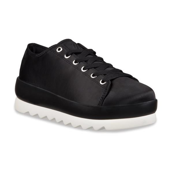tenis casual dama negro K-Swiss, vista 3/4 frontal de tenis para mujer con corte liso negro, cordones planos y ojales metálicos, plataforma media negra con base blanca dentada sobre fondo blanco. Su tamaño compacto los hace adecuados también para uso urbano diario.