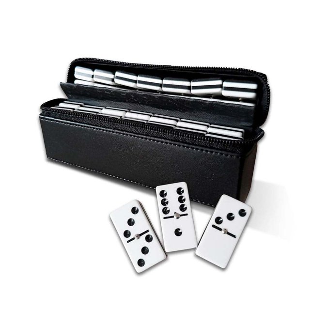 domino dd2 vinyl artik kelvin Estuche viajero negro de curpiel y suede (16.5x3.5x10 cm) abierto con 28 fichas de dominó profesionales acrílicas 4C blancas con puntos negros, vista frontal en 3/4 mostrando la fila interior y tres fichas sueltas en primer plano, adecuado para juegos de mesa y viajes.