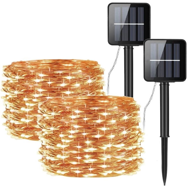 juego de 2 luces solares de cadena de 10 m y 100 led, ip65, impermeables, 8 modos de iluminación, alambre de cobre para jardín, exteriores, fiestas, bodas, patios y navidad dos guirnaldas de cable de cobre de 10 m con 100 LED cálidos cada una, enrolladas y encendidas; incluye dos paneles solares con estaca y cable fino visible, clasificación IP65 y 8 modos seleccionables mediante botón con carga y encendido automáticos — también suelen usarse para ambientar macetas grandes o pequeñas zonas de terraza.