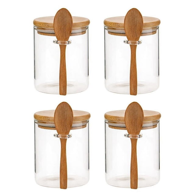 frascos de vidrio con tapa de bambú y cucharas de bambú frascos de vidrio para almacenar alimentos botes de vidrio de borosilicato — cuatro frascos redondos de vidrio transparente con tapas circulares de bambú y sello de silicona en el borde, cada uno con una cuchara de bambú sujeta al frente; vista frontal, apilables para despensa, ideales para almacenar cereales, especias y aderezos, y a menudo usados también para organizar ingredientes al hornear.