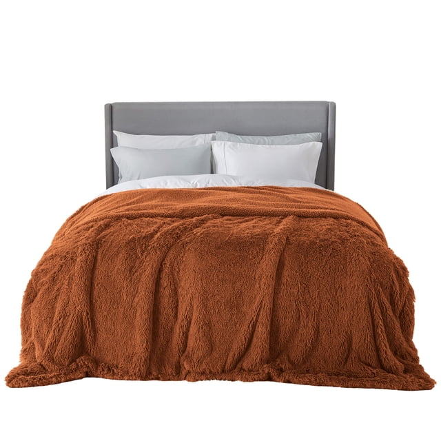 Manta Bedsure Fluffy Burnt Orange King Size para cama de 270 x 230 cm reversible Sherpa; vista frontal centrada de una cama king con la cobija burnt orange extendida sobre la colcha, textura de felpa mullida visible y reverso Sherpa según especificaciones, sobre cabecera gris y almohadas blancas; ideal como cobija decorativa para aportar calidez en interiores y uso en picnic o camping.