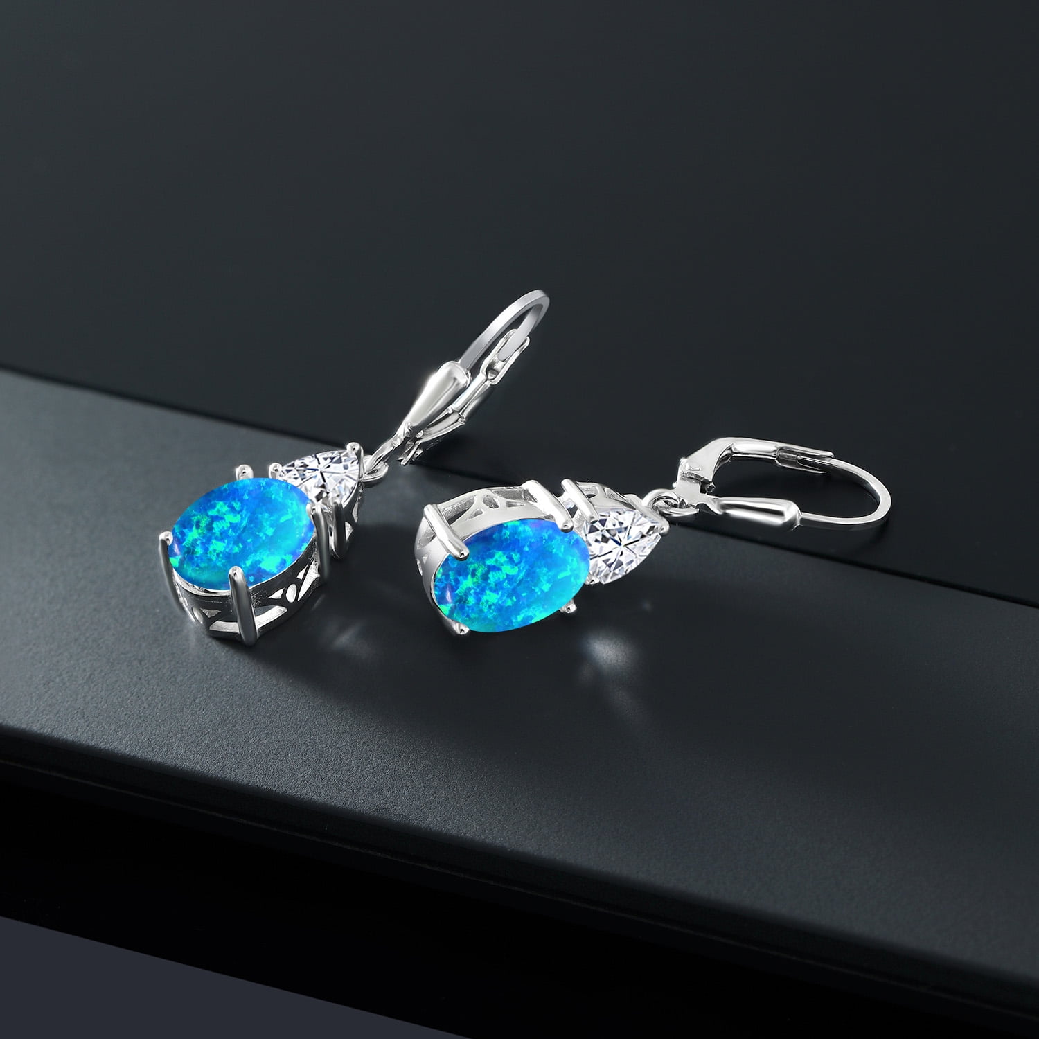 Gem Stone King 925 Sterling Silver Blue Simulated Opal and White Moissanite Dangle Earrings for Women (2.64 Cttw, Gemstone October Birthstone, Oval Cabochon 10X8MM, Trillion 5MM)