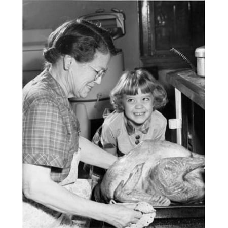Posterazzi SAL2554933 Side Profile of Senior Woman Putting Roasted Turkey in Oven with Her Granddaughter Smiling Poster Print - 18 x 24