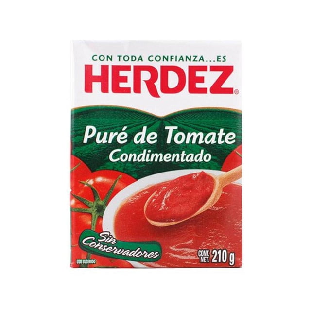 pack de 24 puré de tomate condimentado herdez de 210 gr Caja Tetra Pak frontal con logo Herdez en rojo, texto "Puré de Tomate Condimentado", imagen de puré rojo en cuchara de madera y tomate entero, leyenda "Sin Conservadores" y peso neto 210 g; adecuado para bases de salsas en la despensa.