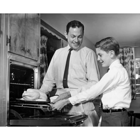 Mid adult man with his son putting a turkey into an oven Canvas Art -  (18 x 24)
