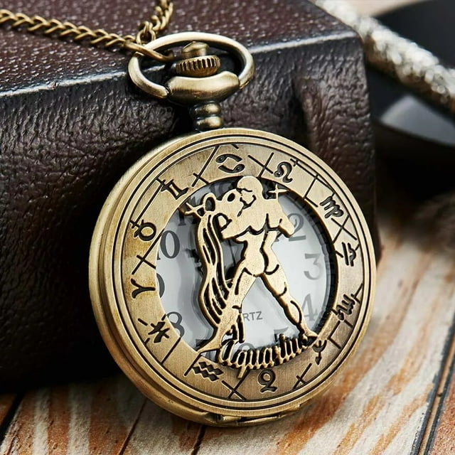 Montre de Poche avec 12 constellations de Collier au Style Créatif et Personnalisé, au design à Thème Verseau. le Boîtier Rond en Alliage Présente une Finition bronze avec des Symboles Complexes du Zodiaque Entourant un Cadran en Verre. le Centre Met en Valeur une Figurine Surélevée du Verseau avec un motif d'Eau, pendant Que le Mouvement à quartz Assure une Mesure Précise de l'Heure. la Montre de Poche Est Unisexe et Conçue pour un Usage Mode et Décontracté, Ce Qui en Fait une option de Cadeau unique. la Montre s'Affiche sur une surface en Bois avec une Boîte en Cuir en Arrière-plan