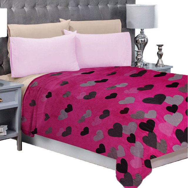 frazada matrimonial ligera estampada, flannel extra suave mod . valentina — cobija matrimonial color VALENTINA con estampado de corazones negros y grises sobre fondo fucsia; vista frontal en cama doble, pliegues que muestran la caída y textura de felpa (100% poliéster); suele usarse como cobija ligera para dormitorio.