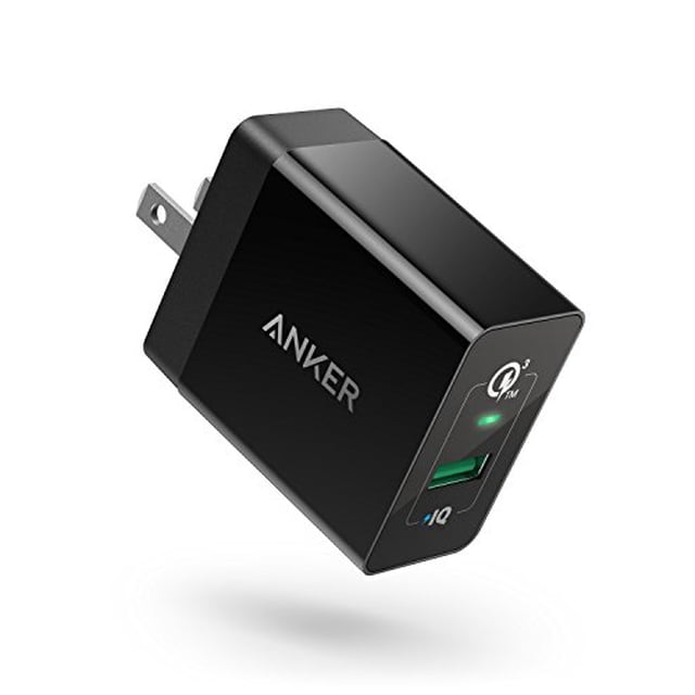 cargador de pared usb anker 18w 3amp carga rápida 3.0 negro. Vista oblicua frontal del adaptador compacto con clavijas tipo A, un puerto USB-A verde con logo PowerIQ y un LED indicador; compatible con Quick Charge 3.0 para celulares y tablets y suele emplearse para cargar dispositivos en viajes.