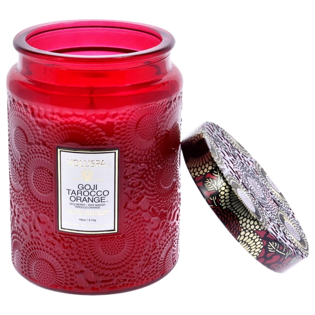 vela de 18 oz con aroma a naranja goji y tarocco, tamaño grande, unisex, de Voluspa: tarro de vidrio rojo con patrón circular en relieve y etiqueta frontal que dice Goji Tarocco Orange; tapa decorativa apoyada a un lado sobre fondo blanco; a menudo se usa como pieza decorativa en salas o comedores.