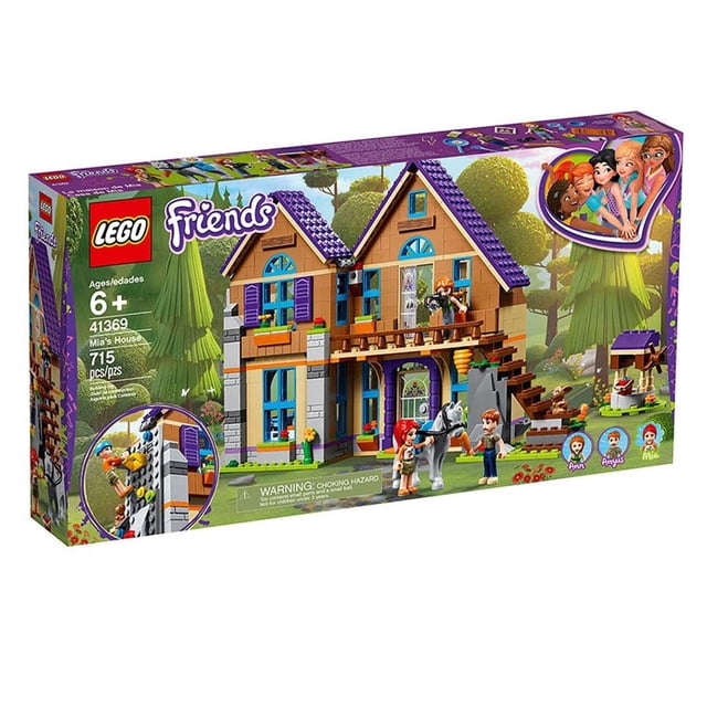Set LEGO Friends Casa de Mia 41369 presenta una casa de dos pisos con techo morado y paredes beige con detalles en azul y naranja. Incluye figuras de Mia, Ann y Angus, un caballo blanco, una pared de escalada y un conejo, ideal para juegos de construcción y crear escenarios familiares en el bosque.