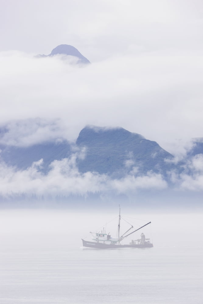 Commercial fishing boat Silver salmon fishing outside of Valdez small boat harbor with misty clouds and mountains in background Prince William Sound Southcentral Alaska USA Canvas Art - Kevin Smith D