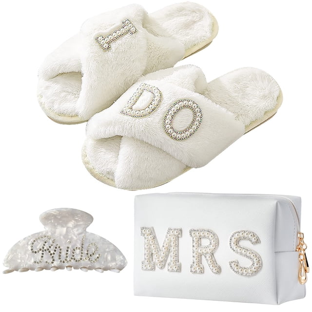 set de regalo tifoda bride to be bride, bolsa de maquillaje i do spantuflas — juego blanco para novia en vista 3/4 con pantuflas peludas cruzadas bordadas con "I" y "DO" en cuentas y diamantes de imitación; bolsa de maquillaje MRS de cuero sintético blanco con parche de perlas y letras de diamantes de imitación; pinza de garra acrílica blanca con detalle "novia" en diamantes de imitación; fondo neutro, también adecuada como regalo para despedida de soltera.
