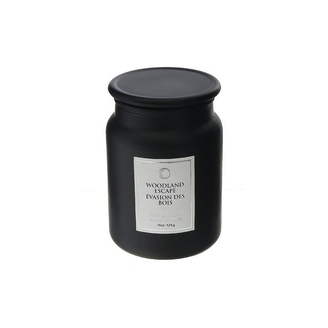 Black 19 oz scented candle jar with glass lid labeled Woodland Escape in elegant font