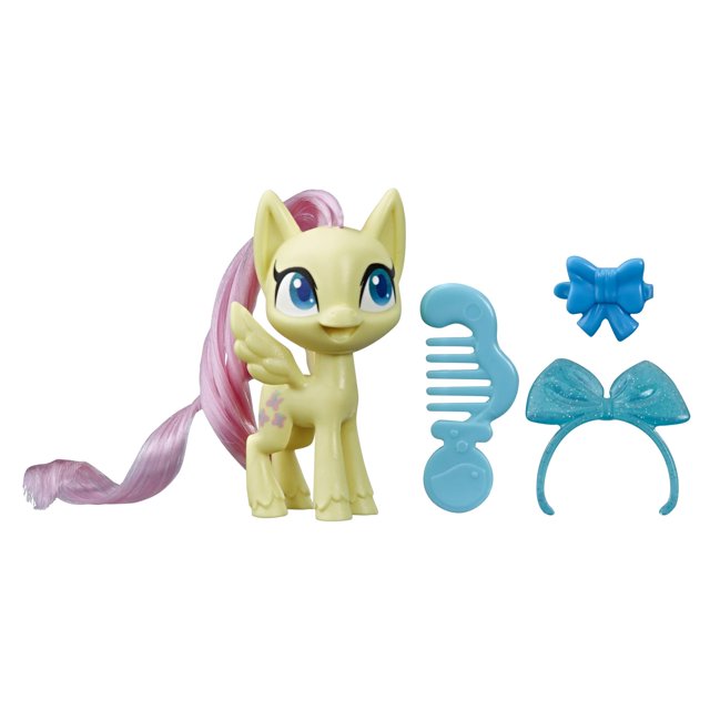poni de poción fluttershy de juguete my little pony con accesorios figura de 3 pulgadas, frontal centrado de poni amarillo con alas y melena rosada cepillable que viene con peine azul, diadema con moño brillante y moño extra como accesorios sorpresa sobre fondo blanco.
