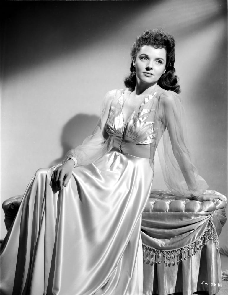 Jane Wyatt Seated on a Couch in White V-Neck Sheer Long Sleeve Silk