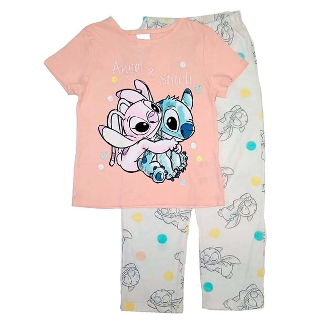pijama disney talla 4 manga corta con estampado stitch multicolor conjunto para niña. Playera rosada manga corta con ilustración frontal de Angel y Stitch abrazados y texto; pantalón blanco con estampado repetido de Stitch en contorno y lunares multicolor; tacto suave, vista frontal sobre fondo claro. También suele usarse como conjunto cómodo para pijama de viaje o descanso.
